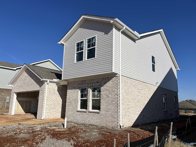 view of side of property with a garage and brick siding