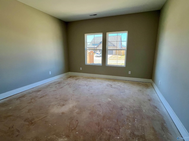 spare room with baseboards, visible vents, and unfinished concrete floors