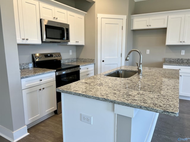 kitchen with appliances with stainless steel finishes, dark wood-type flooring, a sink, and white cabinetry