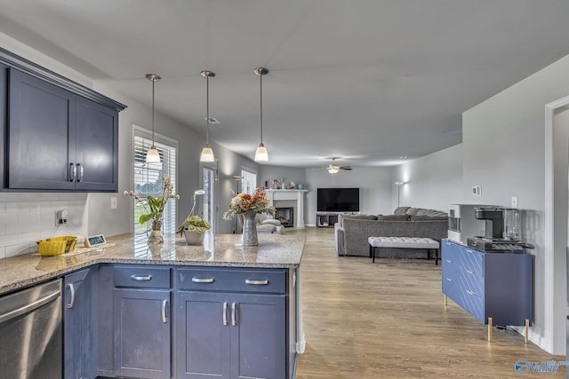 kitchen featuring blue cabinetry, hanging light fixtures, light hardwood / wood-style flooring, dishwasher, and decorative backsplash