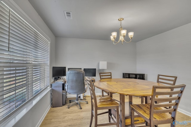 dining room featuring a notable chandelier and light hardwood / wood-style flooring