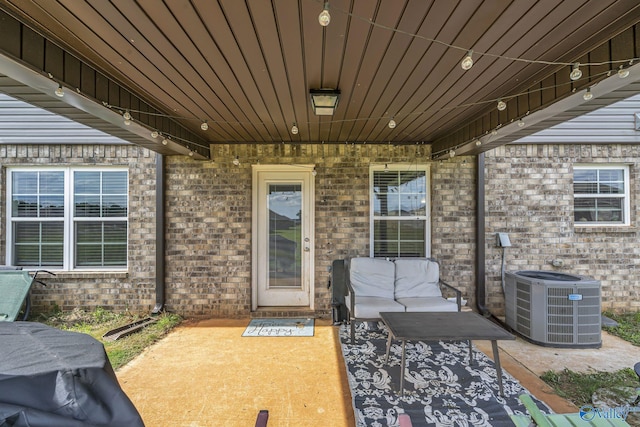 property entrance featuring a patio and central air condition unit