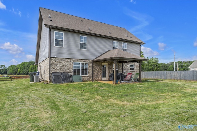 rear view of property featuring central AC, a yard, and a patio