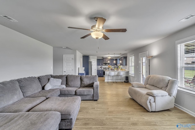 living room with ceiling fan, a healthy amount of sunlight, and light wood-type flooring