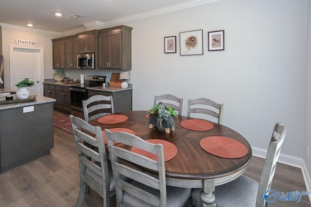 dining area featuring crown molding and dark hardwood / wood-style flooring