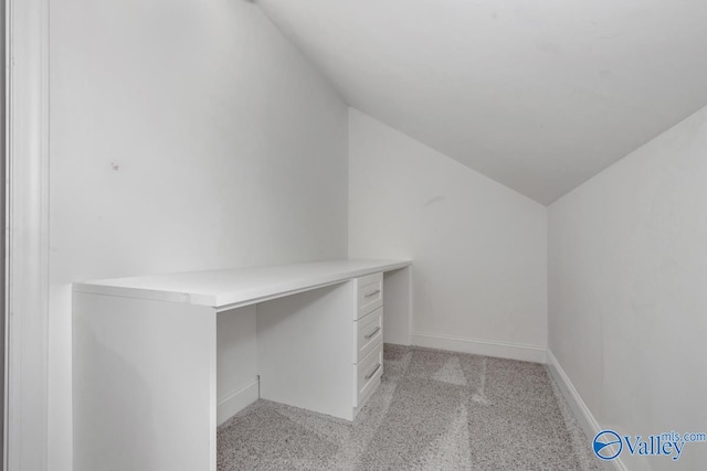 walk in closet with light colored carpet and vaulted ceiling