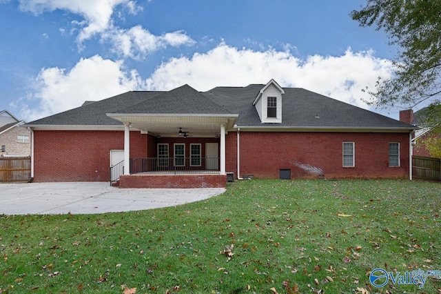 back of property with ceiling fan, a lawn, and a patio