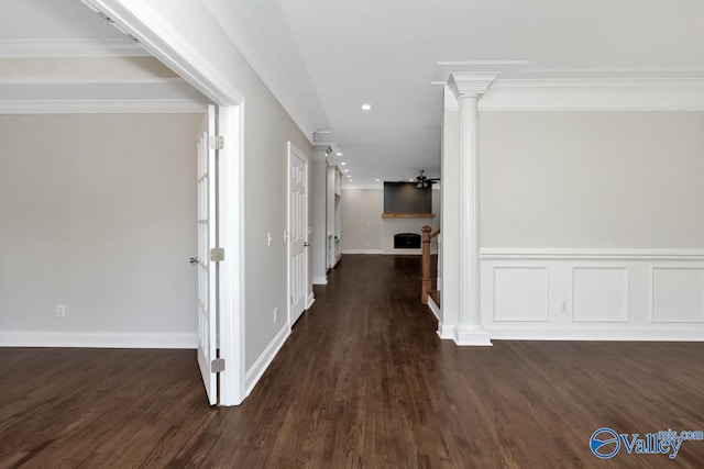 hallway with ornate columns, dark wood-type flooring, and crown molding