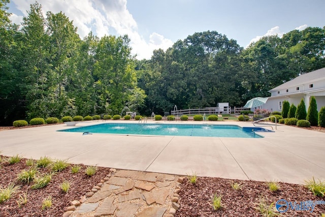 pool with fence and a patio area