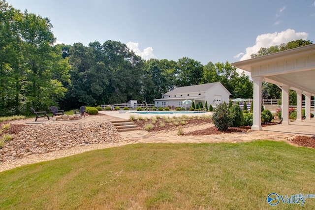 exterior space featuring a lawn, a swimming pool, a patio area, and an outdoor fire pit