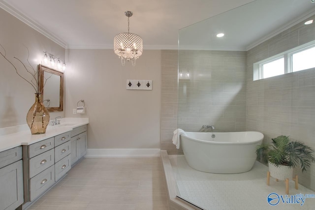 full bath featuring vanity, ornamental molding, an inviting chandelier, baseboards, and a soaking tub