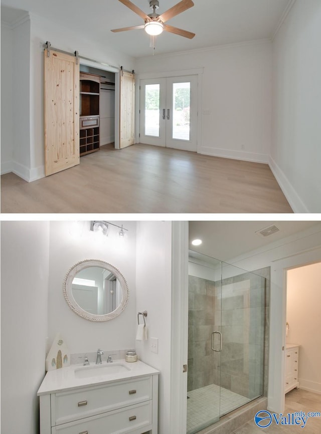 bathroom featuring visible vents, vanity, wood finished floors, ceiling fan, and a stall shower