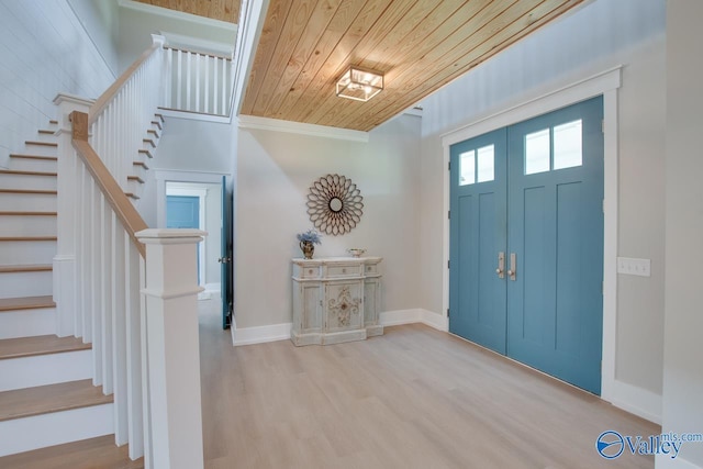 entryway with crown molding, stairs, wood finished floors, baseboards, and wooden ceiling