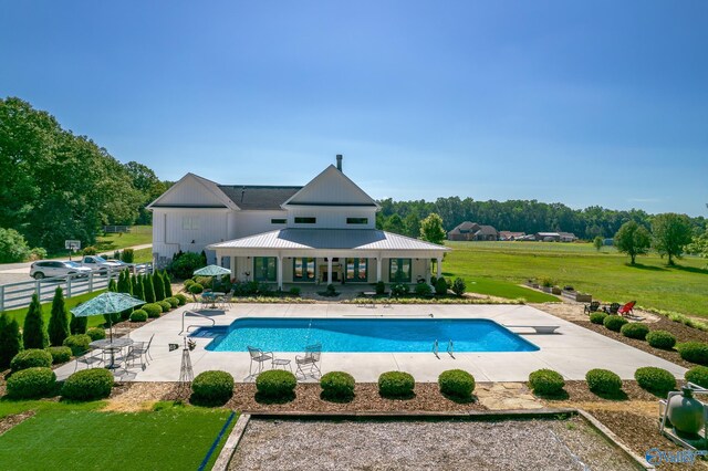 pool with a lawn, a patio, and fence