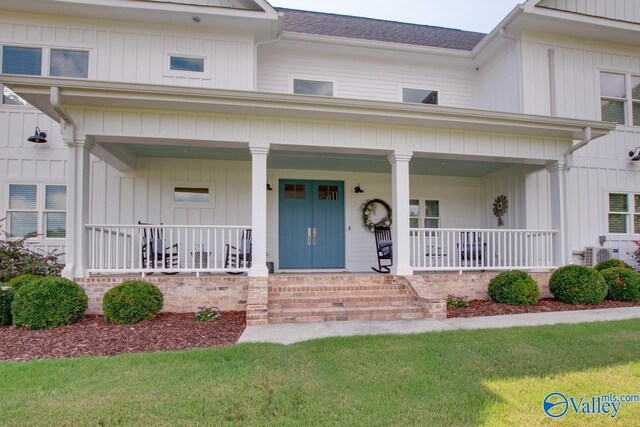 view of front of house with covered porch, board and batten siding, ac unit, and roof with shingles