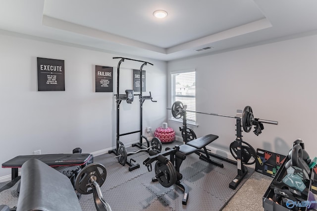 workout room with a tray ceiling