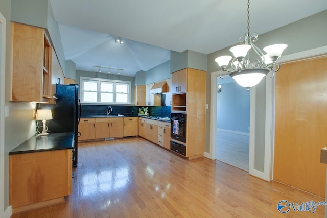 kitchen featuring dark countertops, light brown cabinetry, black appliances, wall chimney exhaust hood, and a sink