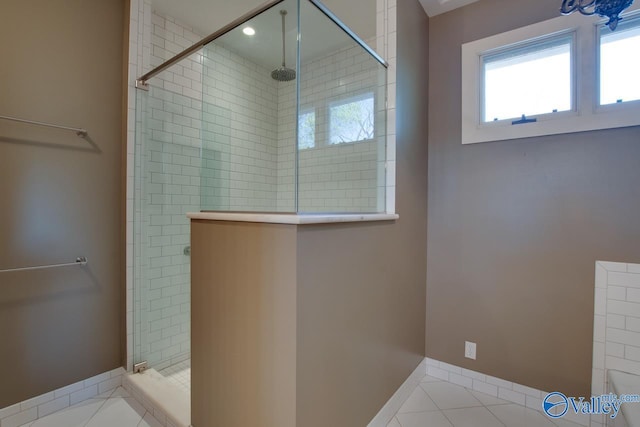 bathroom featuring tile patterned floors, a stall shower, and baseboards