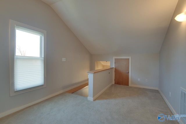 additional living space with baseboards, carpet floors, and vaulted ceiling