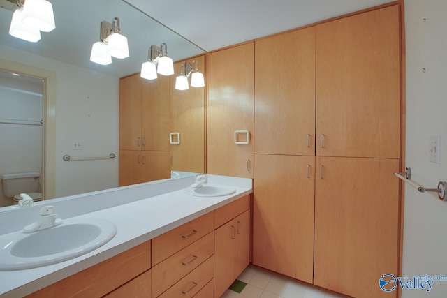 full bathroom featuring double vanity, toilet, and a sink