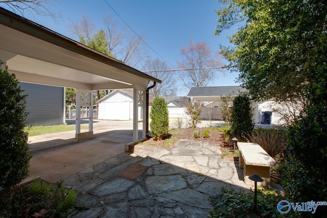 view of patio with a storage unit, an outdoor structure, and fence