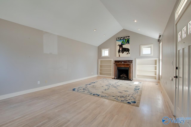 unfurnished living room featuring a fireplace with flush hearth, baseboards, light wood-type flooring, and high vaulted ceiling