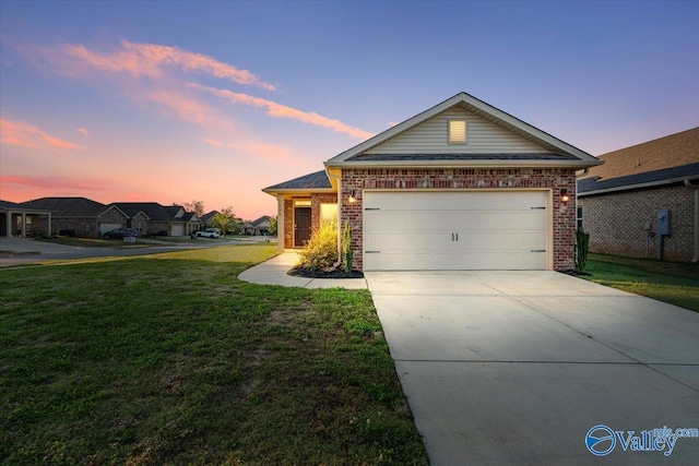 single story home featuring brick siding, an attached garage, a front yard, and concrete driveway