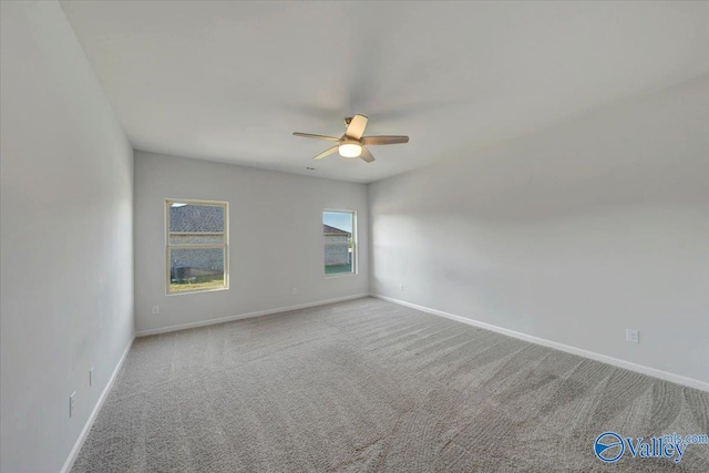 carpeted spare room with ceiling fan and baseboards
