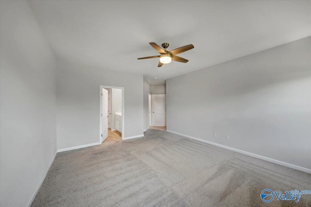 unfurnished bedroom featuring ensuite bath, a ceiling fan, baseboards, and light colored carpet