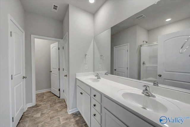full bath with visible vents, baseboards, a sink, and a stall shower