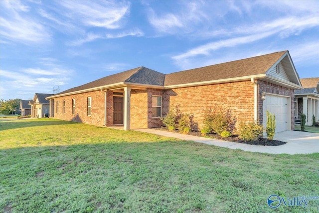 view of front facade with a front lawn, driveway, a shingled roof, an attached garage, and brick siding