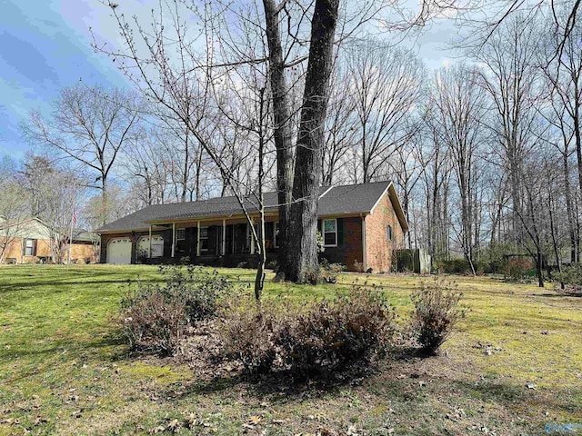 ranch-style house with a garage, a front lawn, and brick siding