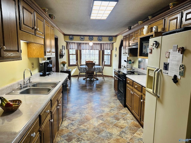 kitchen featuring black appliances, crown molding, light countertops, and a sink