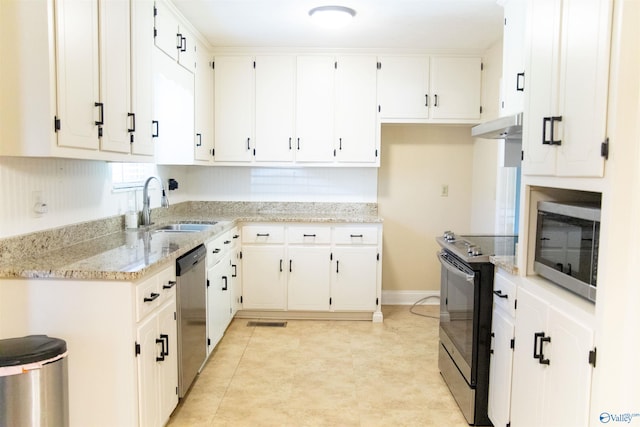 kitchen with stainless steel appliances, light tile patterned flooring, white cabinetry, sink, and light stone countertops