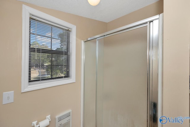 bathroom featuring walk in shower and a textured ceiling