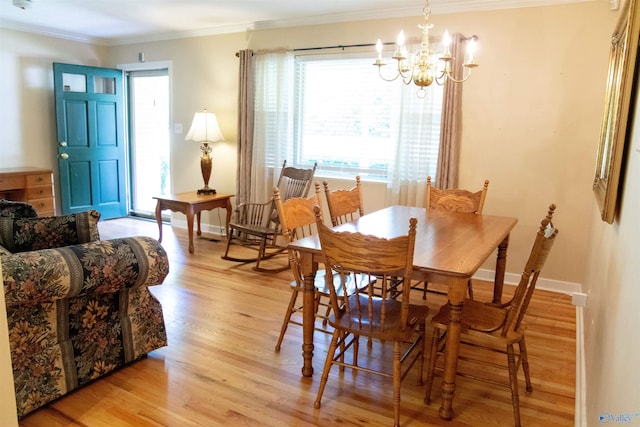 dining room featuring a chandelier, light hardwood / wood-style floors, and crown molding