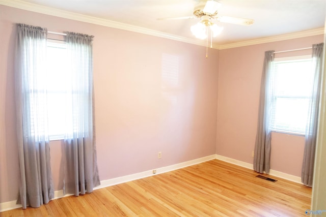 empty room featuring hardwood / wood-style floors, a healthy amount of sunlight, and crown molding