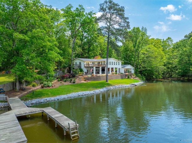 view of dock featuring fence, a forest view, a yard, and a water view