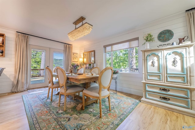 dining area featuring wooden walls, a wealth of natural light, and french doors