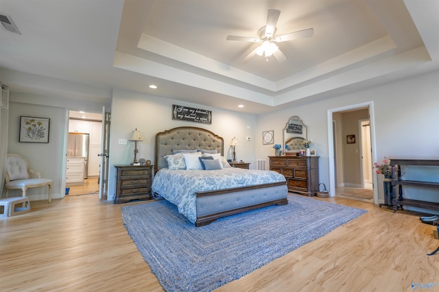bedroom with recessed lighting, a raised ceiling, light wood-type flooring, and baseboards
