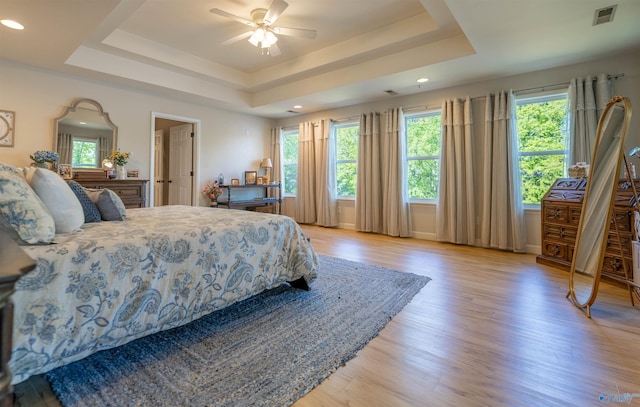 bedroom with recessed lighting, a raised ceiling, visible vents, light wood-type flooring, and ceiling fan