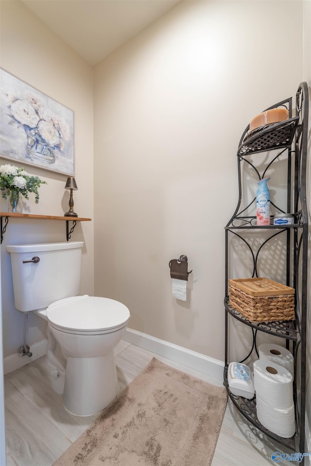 bathroom with toilet and baseboards
