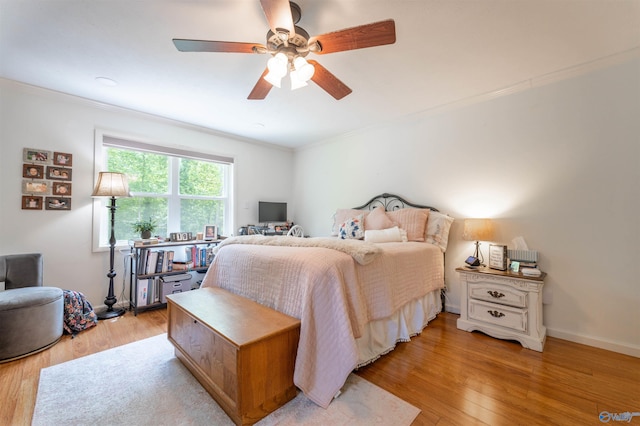 bedroom with light wood-type flooring, crown molding, and ceiling fan