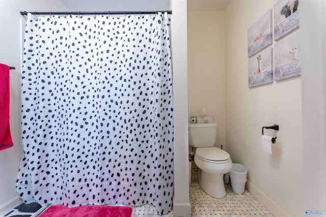 full bathroom with curtained shower, toilet, and baseboards