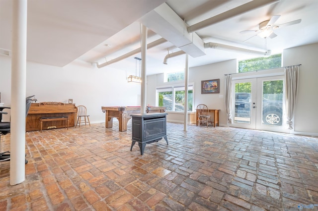living room featuring a ceiling fan, brick floor, french doors, beamed ceiling, and baseboards