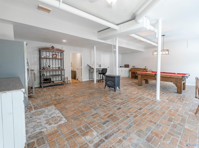 below grade area featuring brick floor, pool table, ceiling fan, baseboards, and freestanding refrigerator