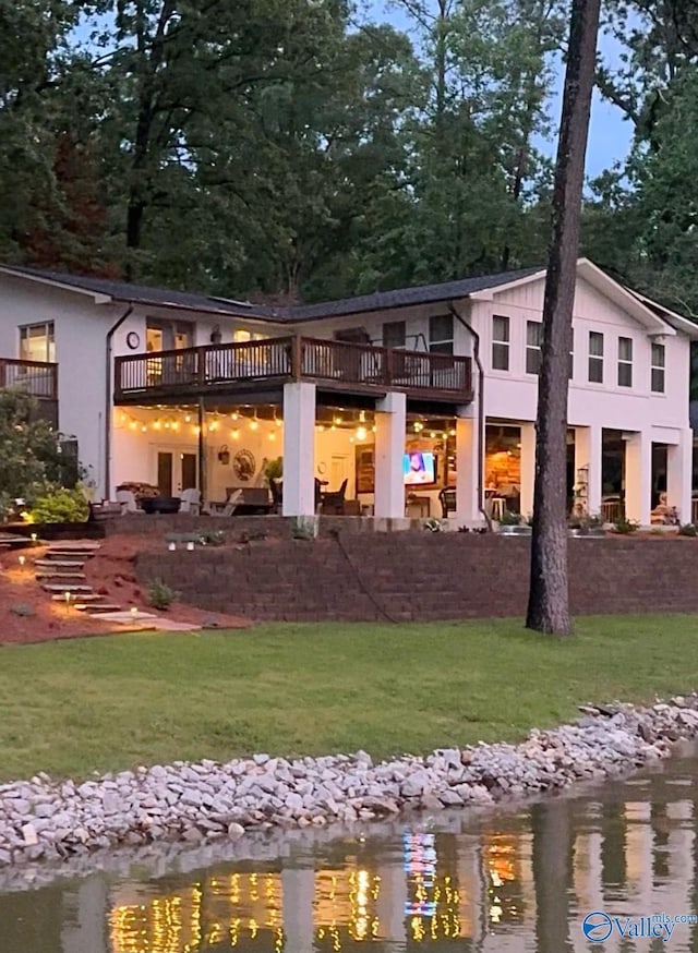 rear view of house with a lawn and a water view