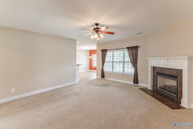 unfurnished living room with dark colored carpet, ceiling fan, and a tile fireplace