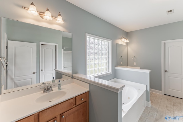 bathroom featuring tile patterned floors, a washtub, and vanity