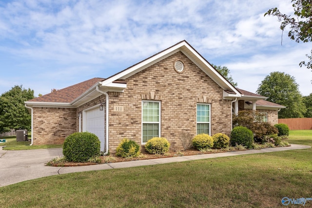 view of front of house with a garage, central AC unit, and a front lawn